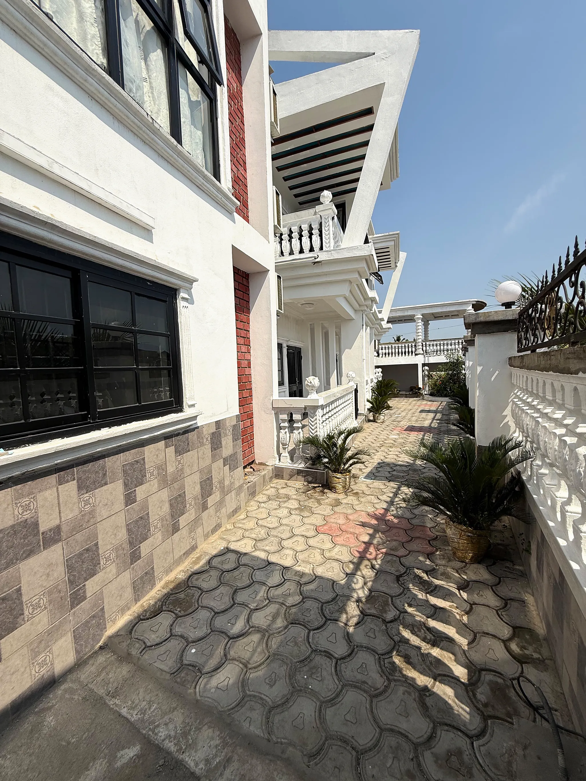 Side path along the building with potted palms