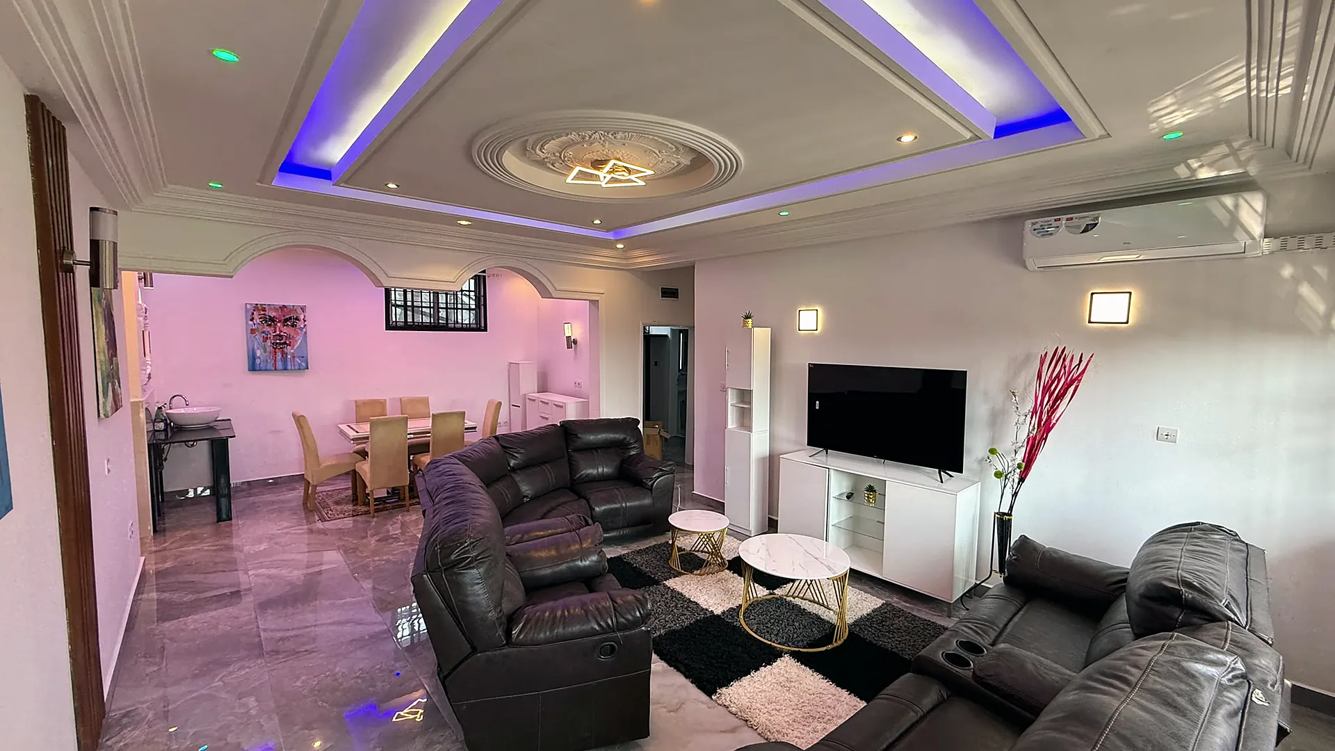 The main living area with its lit ceiling, opening to the dining room